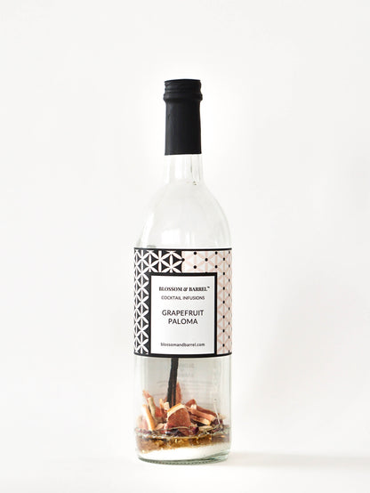 Bottle of Grapefruit Paloma cocktail mix with decorative elements on a white background
